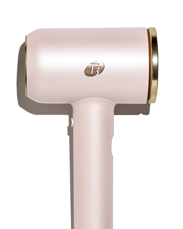Pink hair dryer with gold accents on a white background