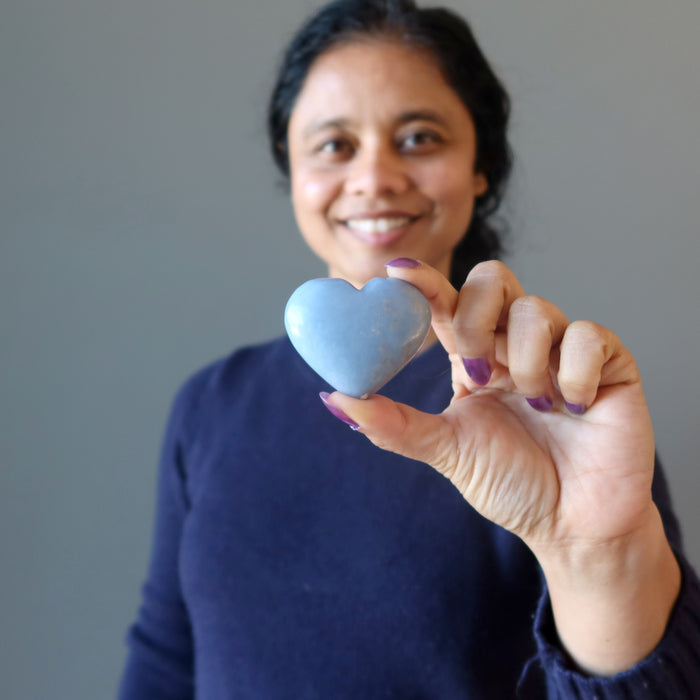 woman holding angelite heart
