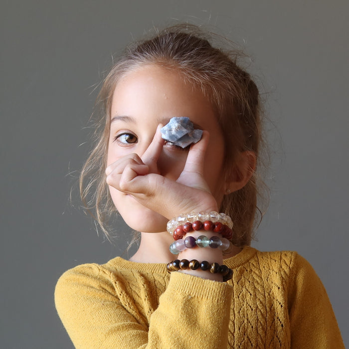 Zoe of satin crystals holding a raw blue calcite