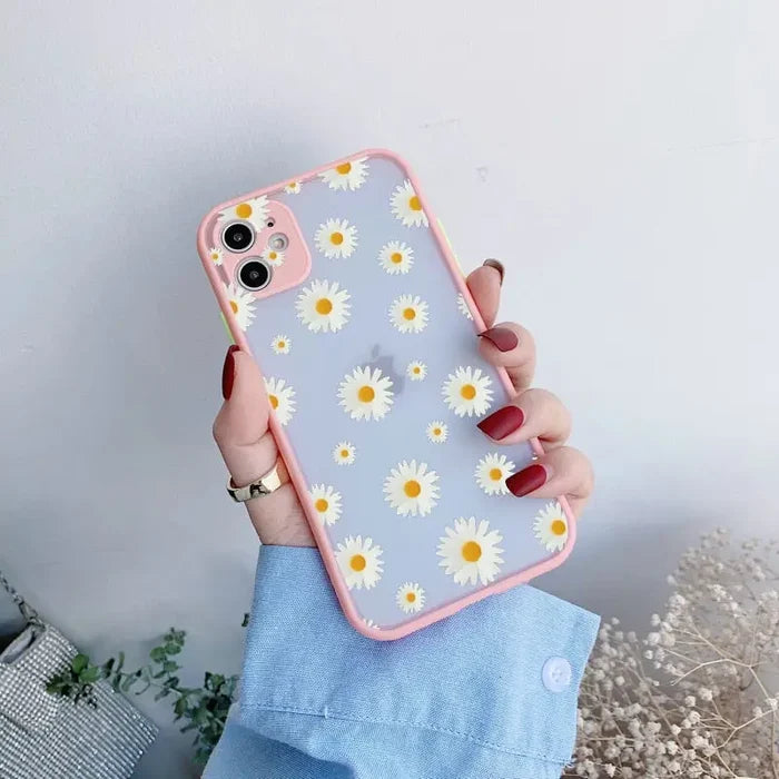 A woman holding a phone case with daisies on it