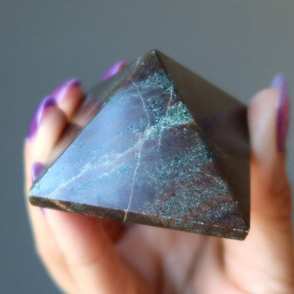 hand holding red garnet pyramid