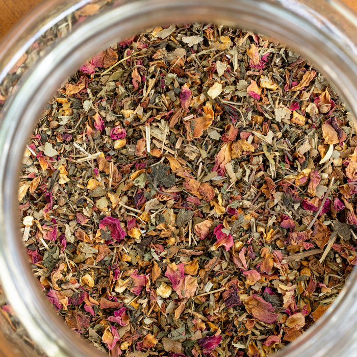 Close-up of a jar filled with a mix of dried herbs and flowers.