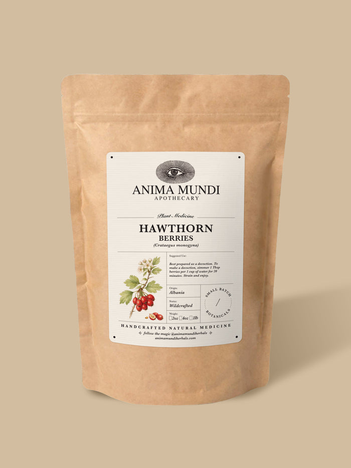 A kraft paper stand-up pouch of Anima Mundi Apothecary Hawthorn Berries, featuring a white label with botanical illustrations of the berries, set against a solid beige background.