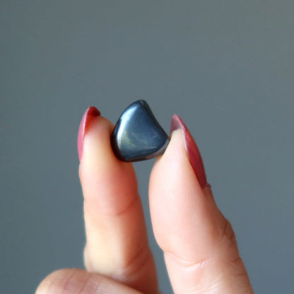 finger tips holding Hematite Tumbled Stone