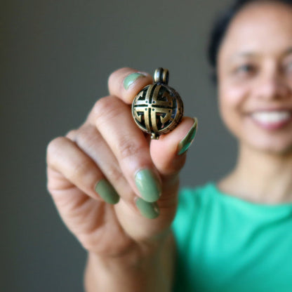 sheila of satin crystals holding moldavite locket pendant