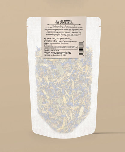 A stand-up pouch of herbal tea with a beige label reading 'COME HOME TO YOURSELF' and product details, shown against a solid beige background.