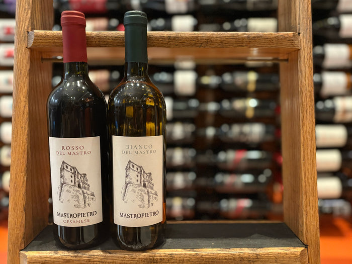 Two labeled wine bottles on a wooden shelf