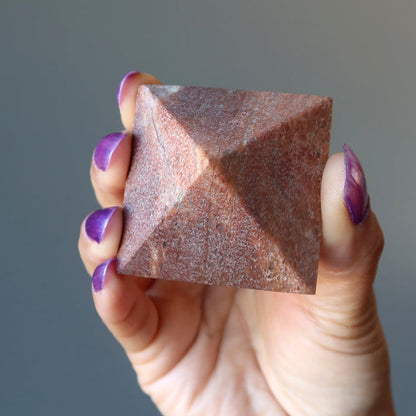 hand holding pink aventurine pyramid