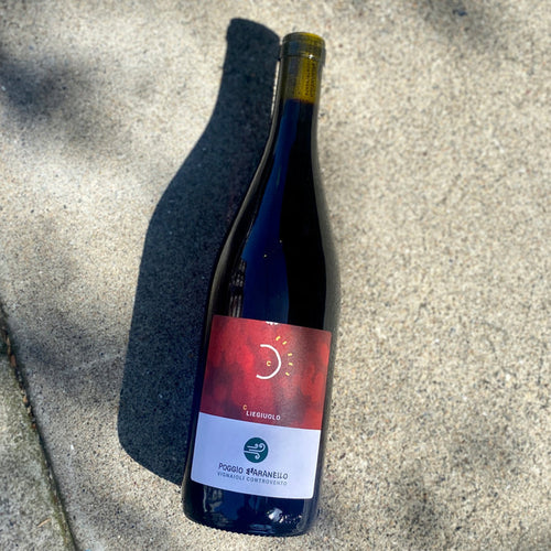 2020 red wine bottle, blue glass with red label (Poggio Bbaranello)