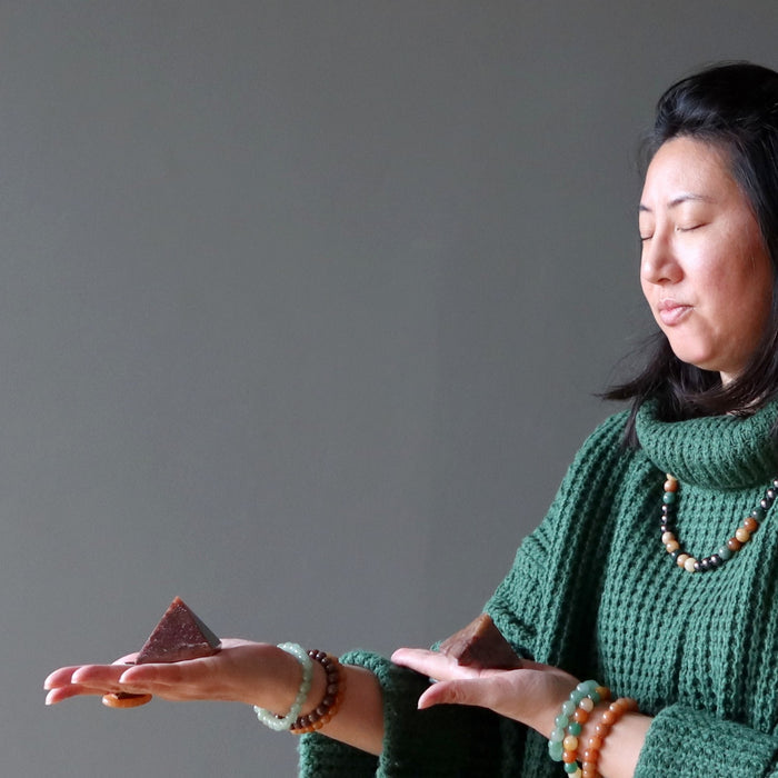 woman meditating with aventurine pyramid