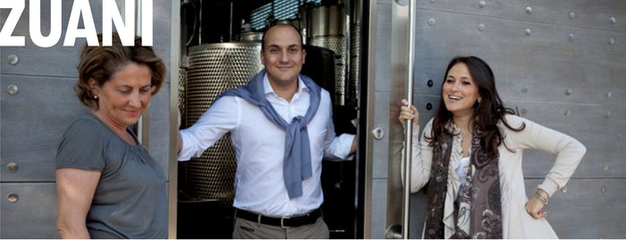 Wine tasting ticket showing three people at winery tanks.